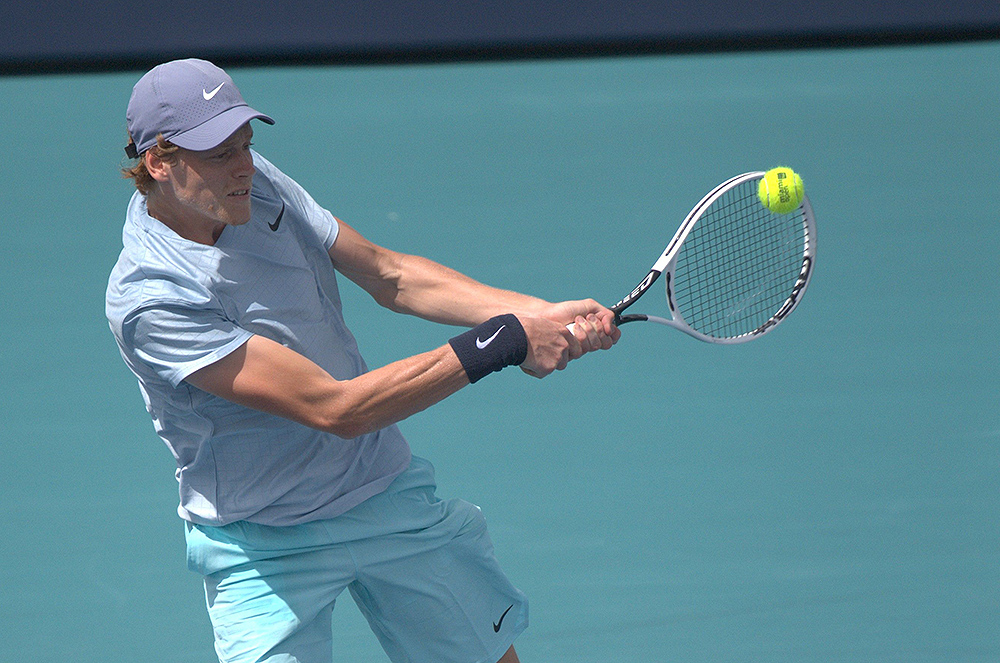 Jannik Sinner demonstrating a modern two-handed backhand drill with a tennis ball machine in Singapore. Photo: Sinner practicing with structured feeds for backhand improvement.